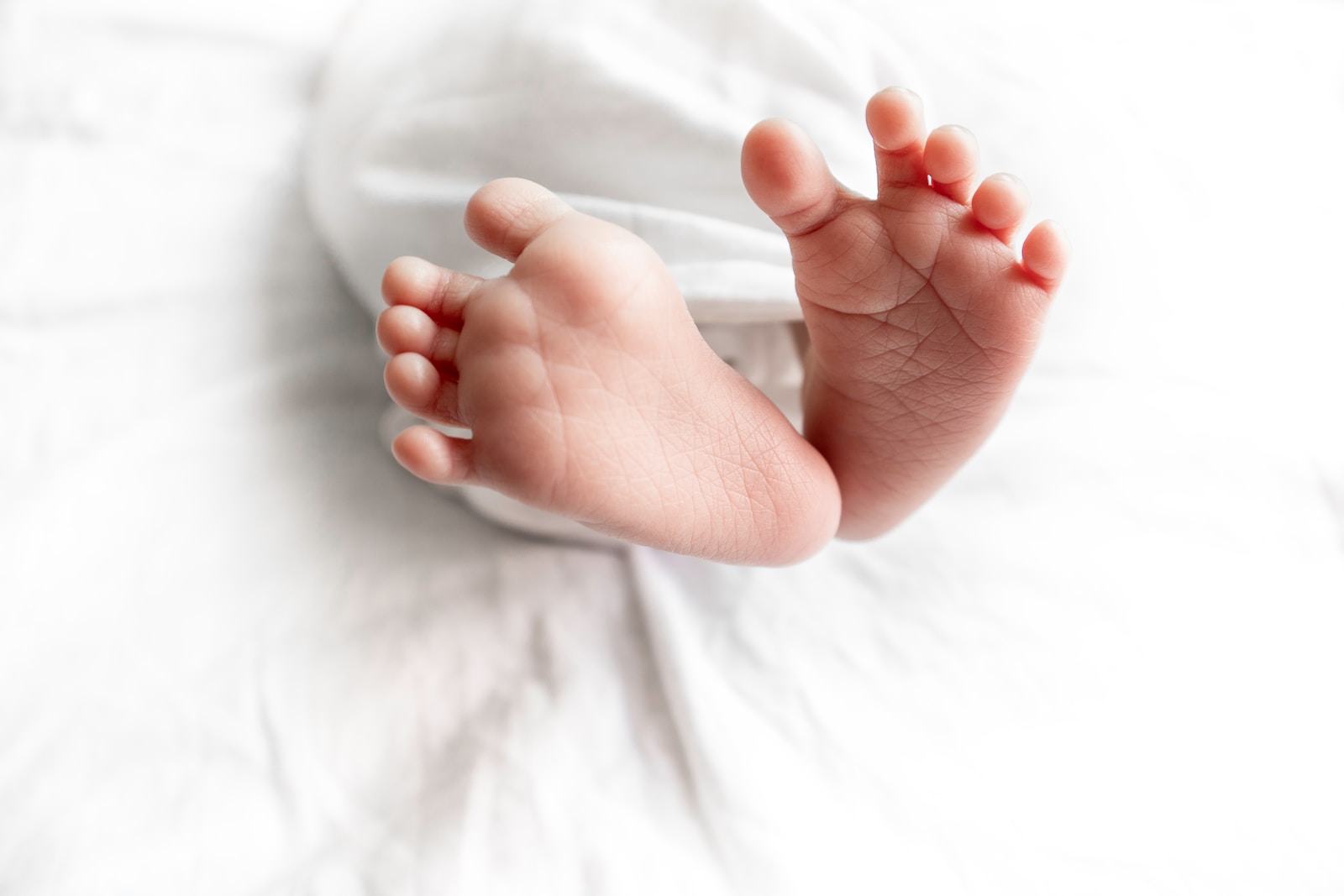 a close up of a baby's bare feet on a bed