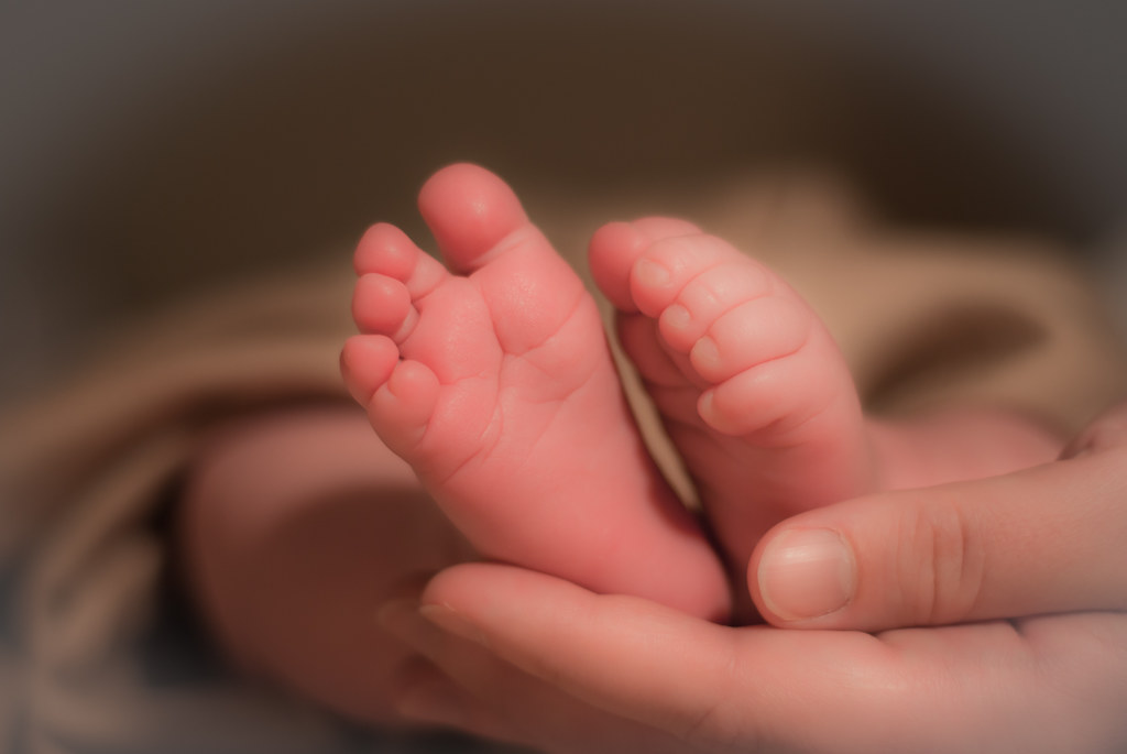 Newborn feet on mother's hands